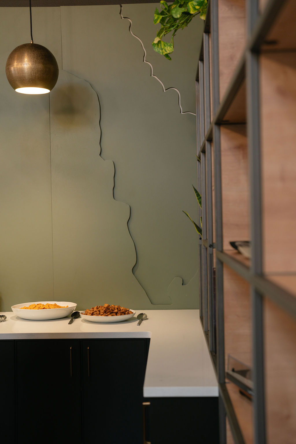 The Outrider Hotel breakfast bar with topographic wall art and warm pendant lighting