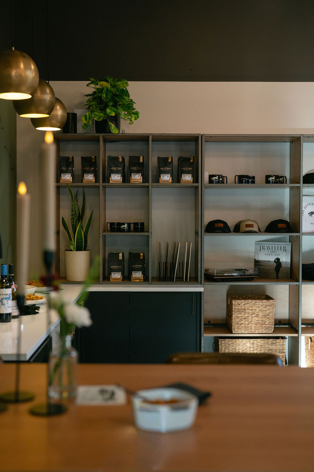 The Outrider Hotel lobby shelves with Hold Fast coffee, Outrider hats, and brass pendant lights