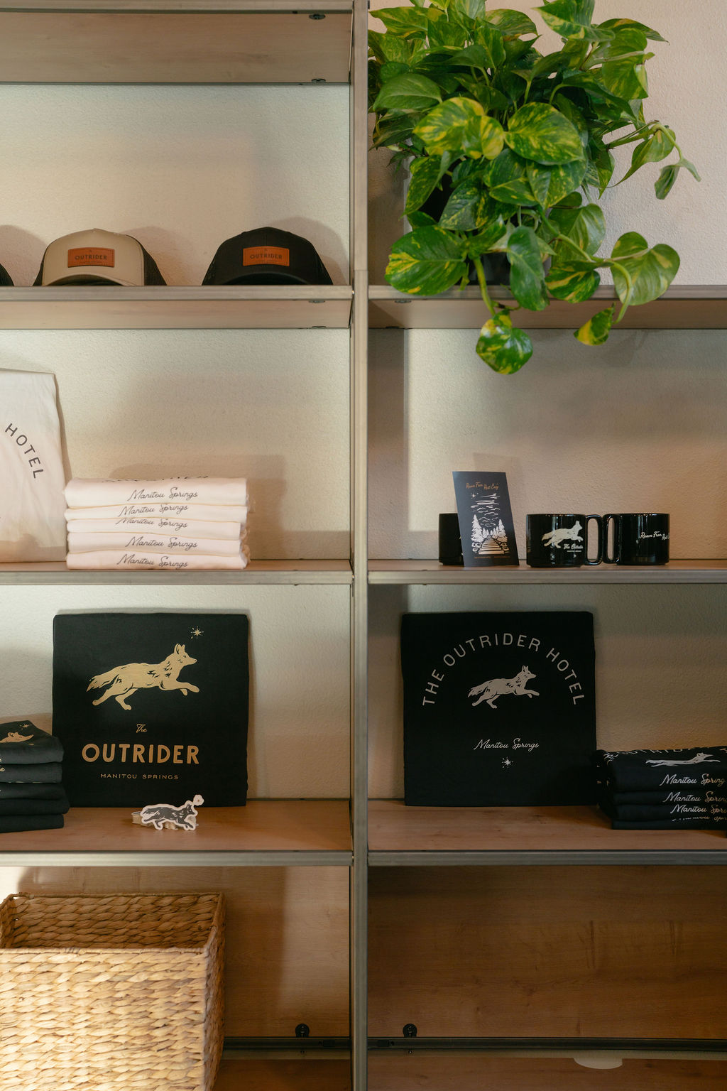 The Outrider Hotel merchandise display with lit shelves showcasing hats, shirts, and branded goods