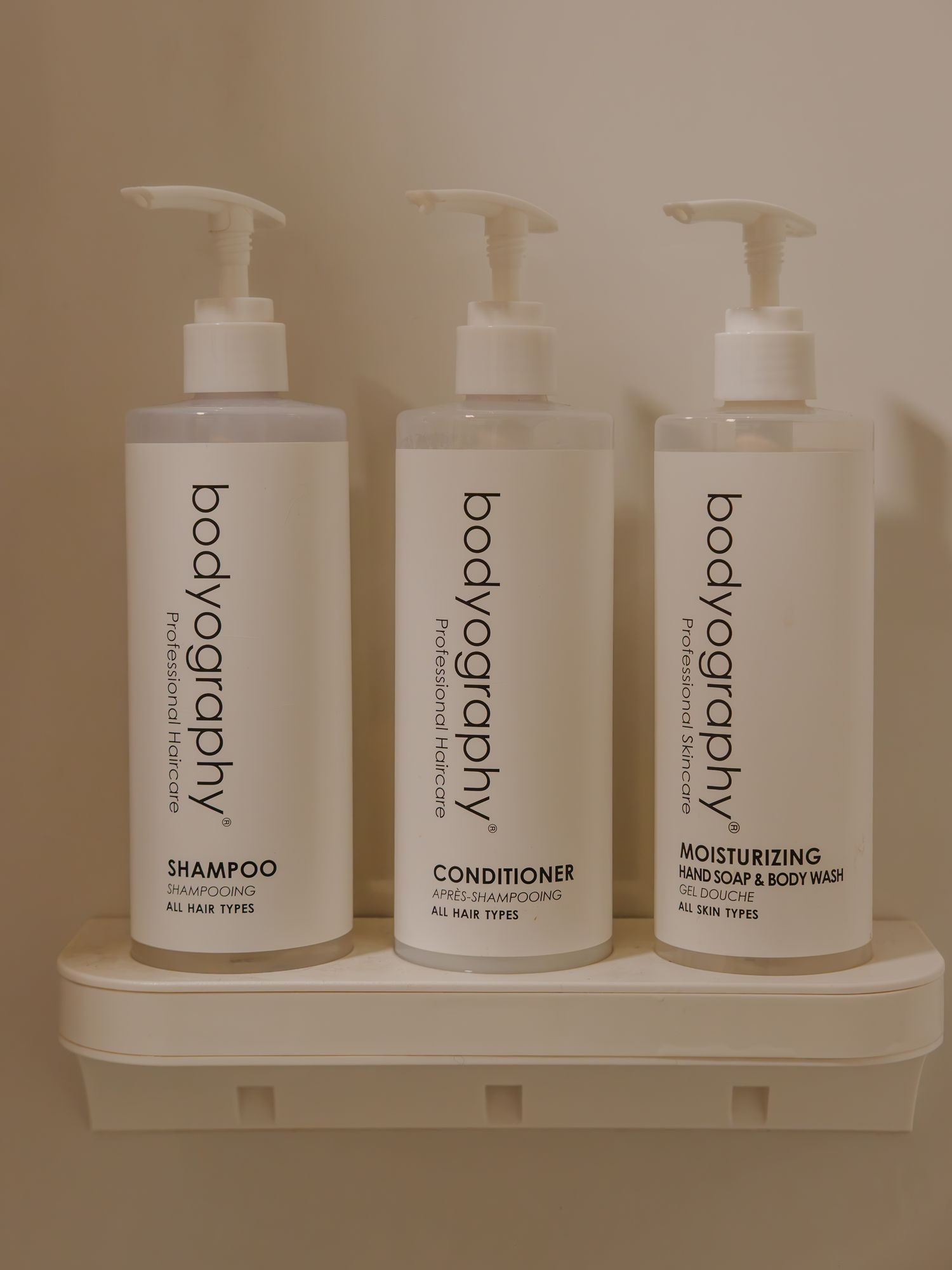 Bodyography shampoo, conditioner, and body wash dispensers in a guest bathroom at The Outrider Hotel
