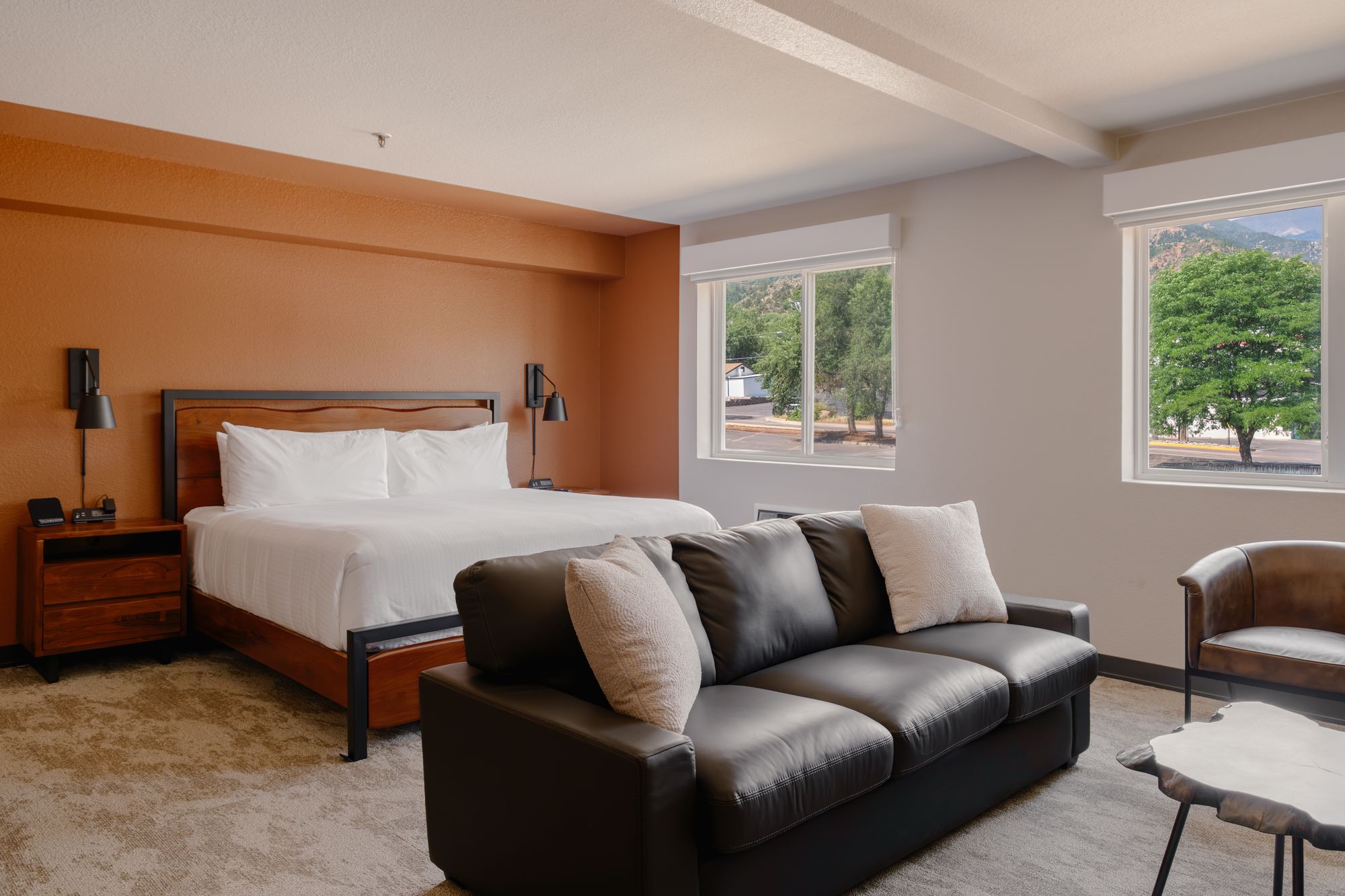 Grand King Suite at The Outrider Hotel with a king bed, leather sofa and sitting area