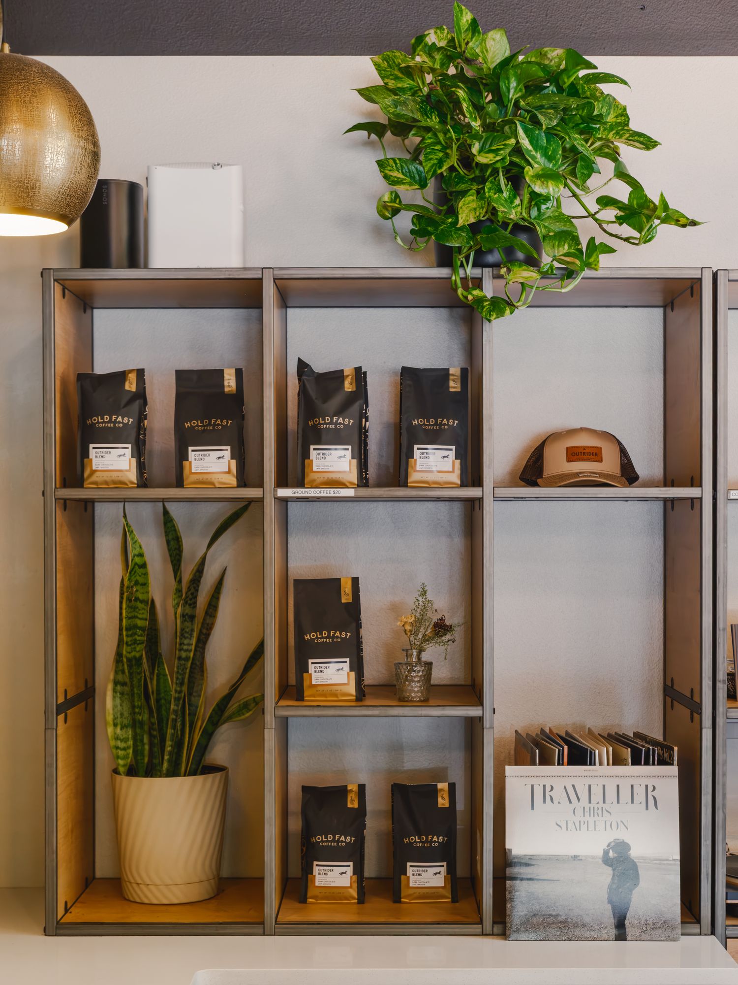 Lobby shelves stocked with local coffee, plants, and Outrider goods at The Outrider Hotel in Manitou Springs