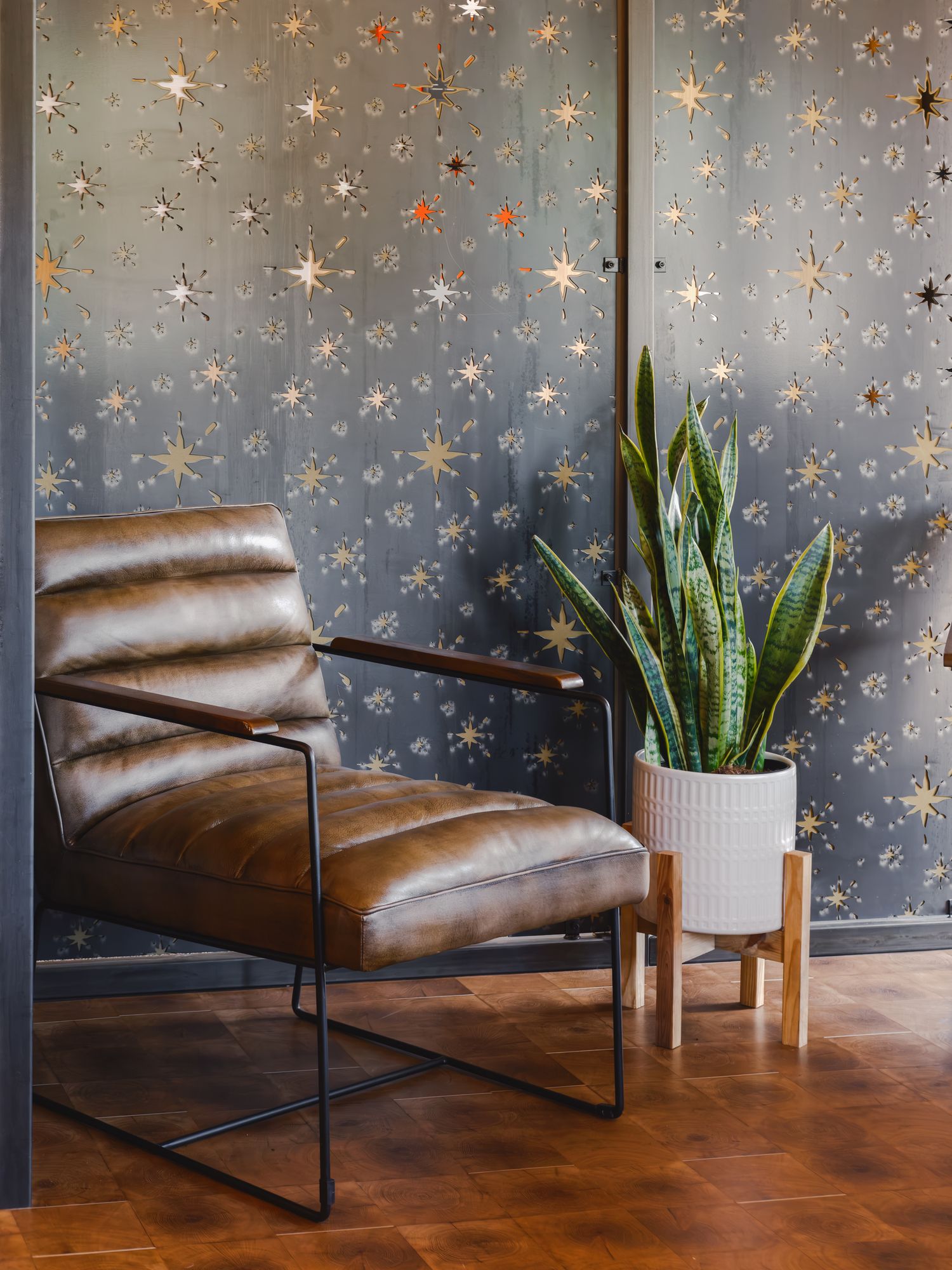 Leather lounge chair against the star-cutout feature wall in The Outrider Hotel lobby