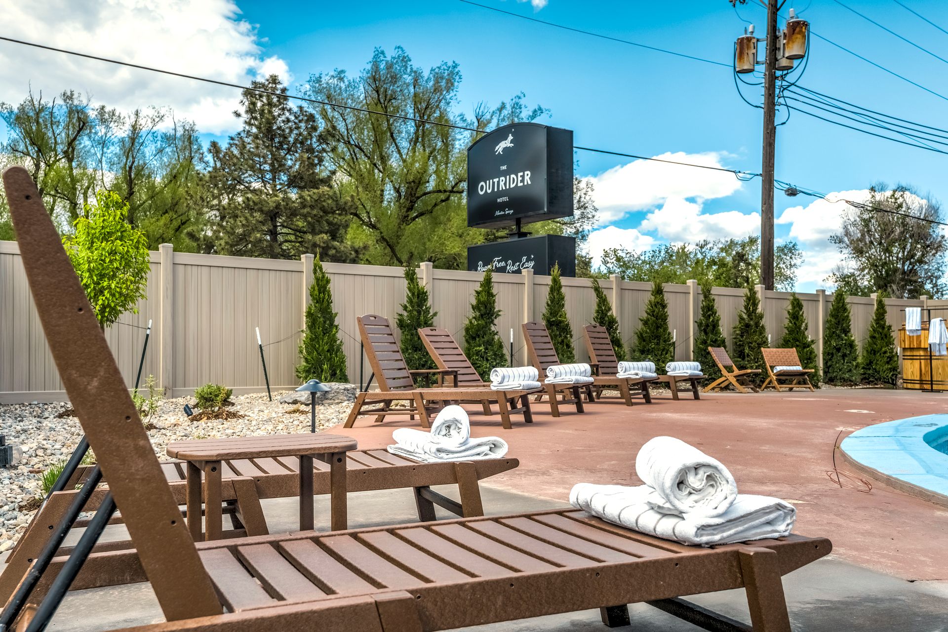 Pool patio with loungers at The Outrider Hotel